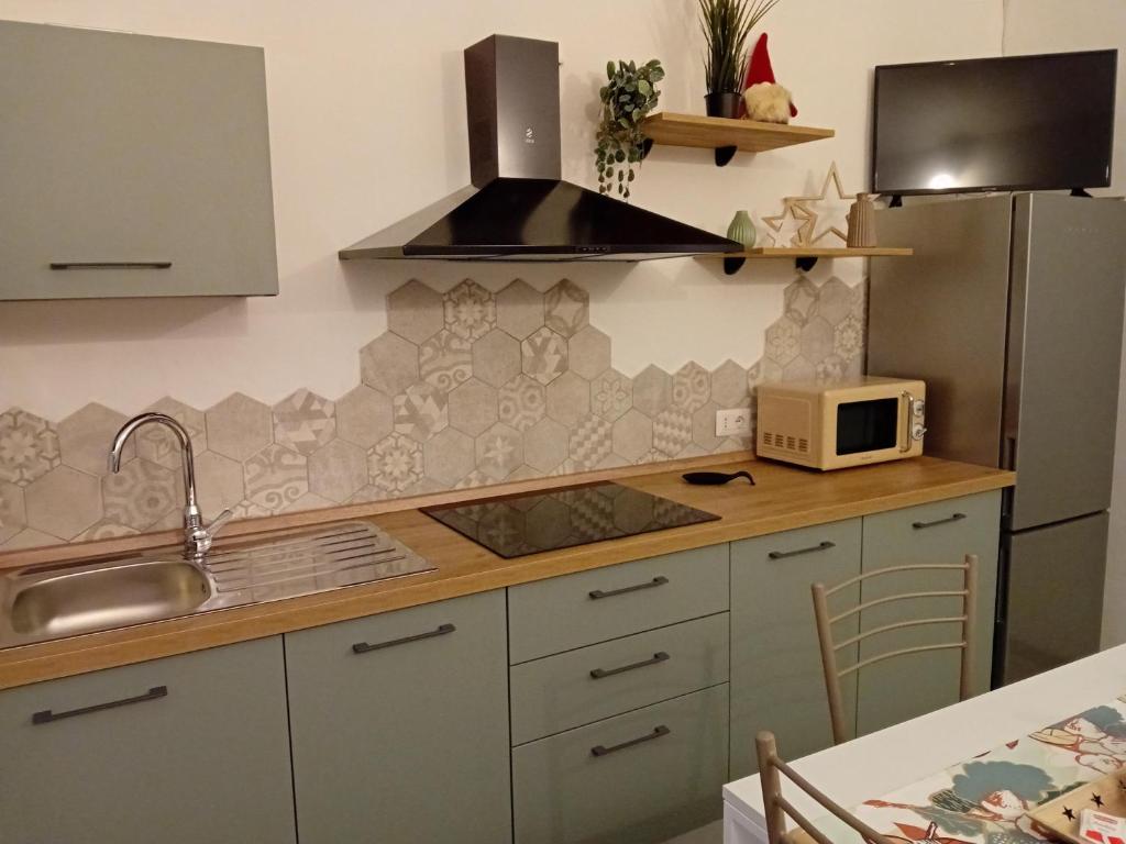 a kitchen with a sink and a microwave at Petite Maison in Asti