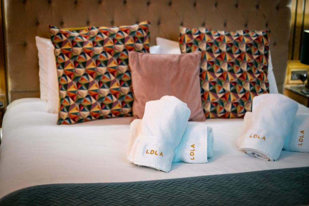 a bed with two towels and pillows on it at Queen's Loft in Windermere