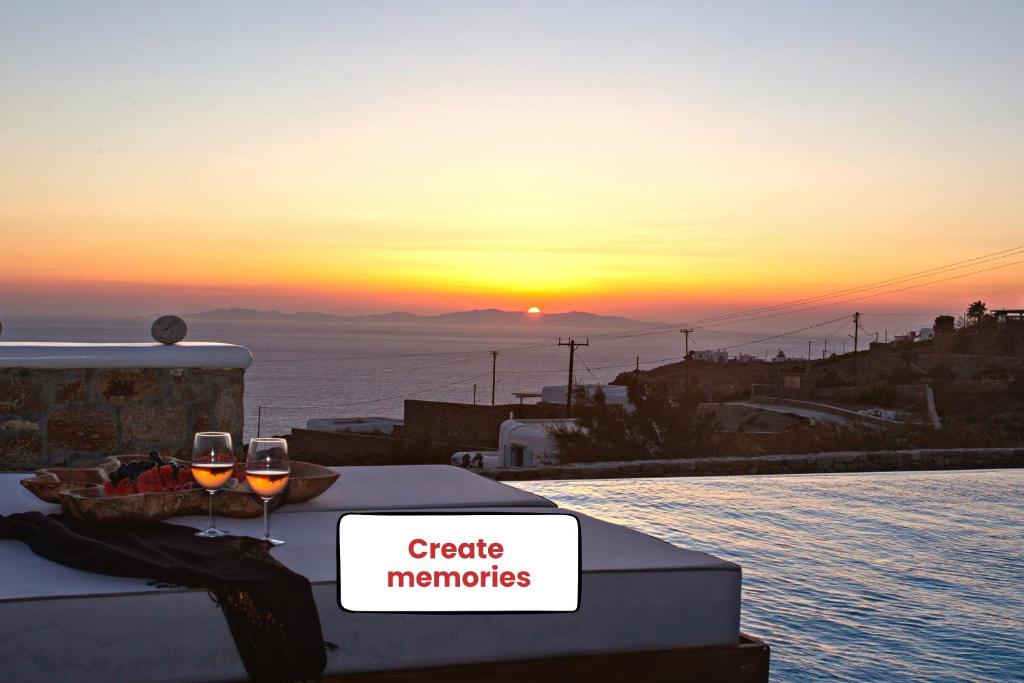 a table with two glasses of wine with the sunset at Villa Panamera, Private Heaven, Supreme View in Fanari