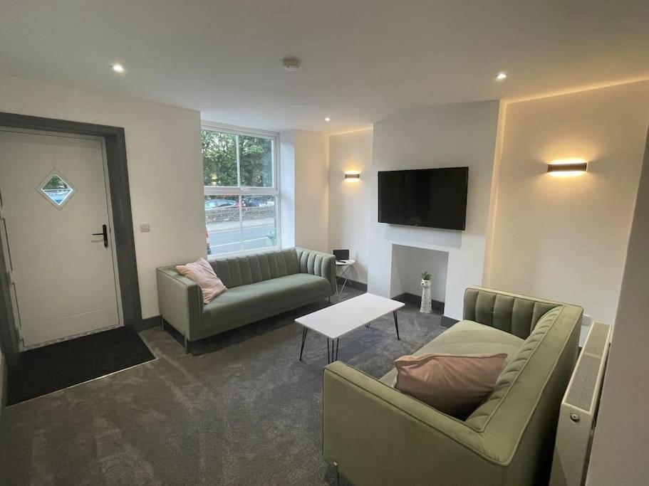uma sala de estar com dois sofás e uma mesa em Cottage in Holmfirth Centre em Holmfirth