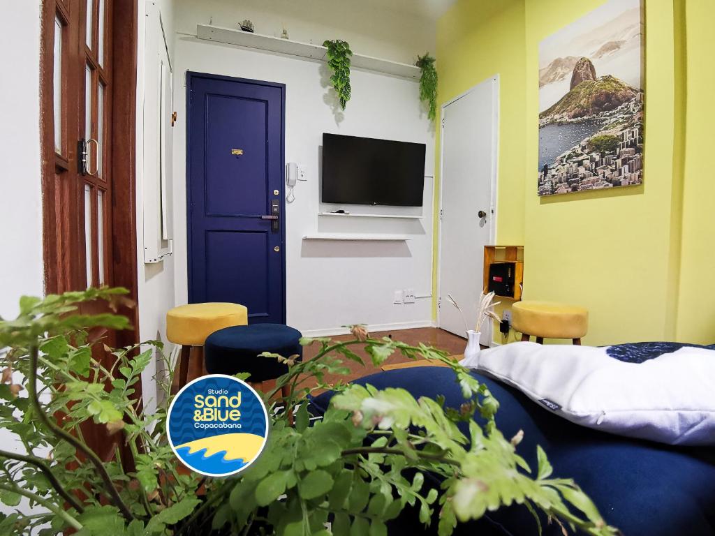 a room with a blue door and a tv at Studio Sand & Blue Copacabana Beach in Rio de Janeiro