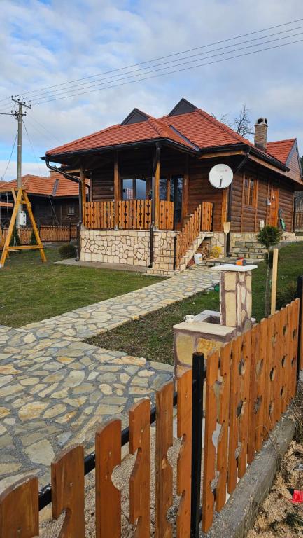 drewniany dom z płotem przed nim w obiekcie Eko kuća Zlatiborsko srce w mieście Zlatibor