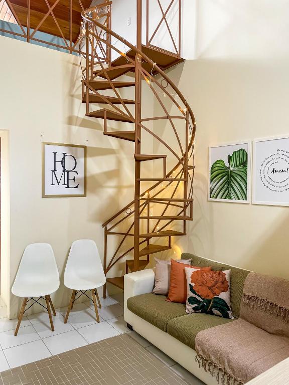 a spiral staircase in a living room with a couch and chairs at Flat Condomínio Monte Castelo Gravatá in Bezerros