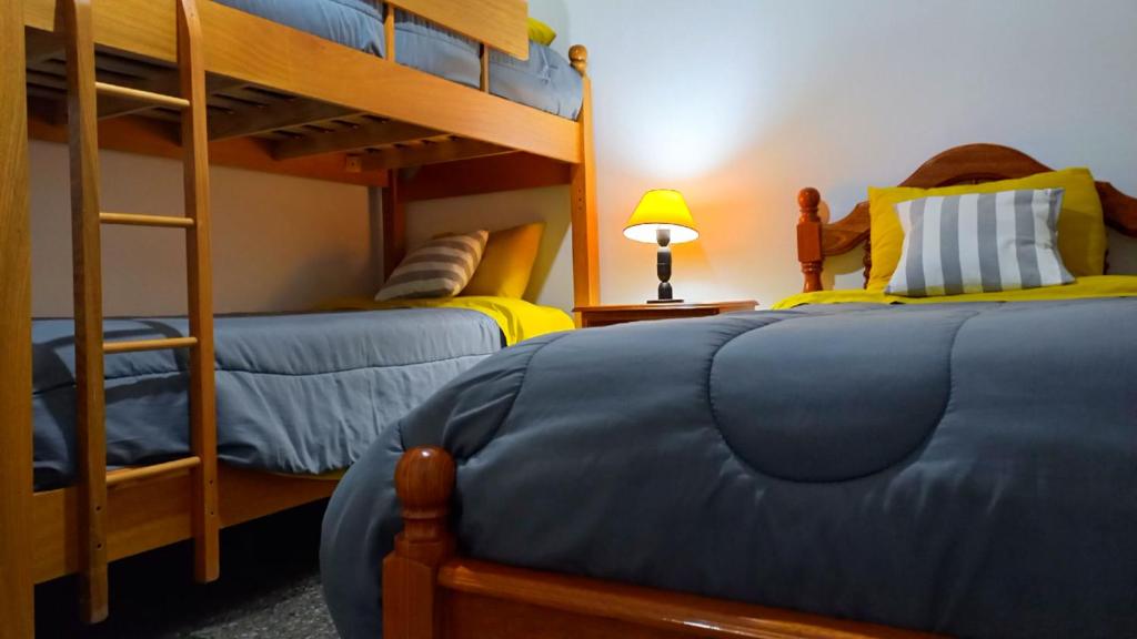 a bedroom with two bunk beds and a lamp at Sueños del Pilar in Godoy Cruz