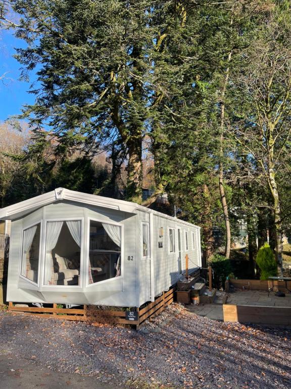 a white trailer is parked in a parking lot at The Beeches Holiday Home- based at Aberdunant Hall Holiday Park in Prenteg