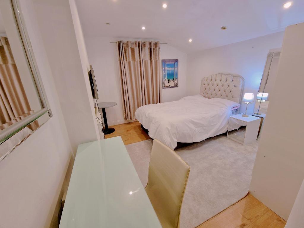 una camera con letto, tavolo e specchio di Cosy Studio Apartment In FULHAM a Londra