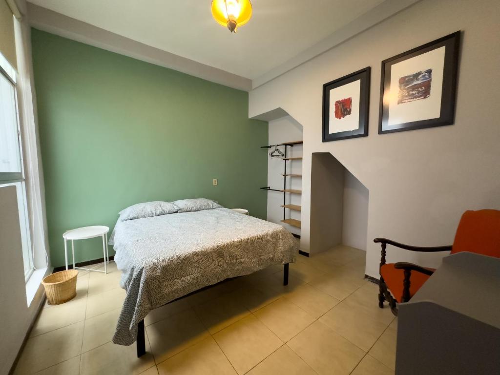 um quarto com uma cama numa parede verde em Cuarto 2 - Roma Norte Cama Queen Size em Cidade do México
