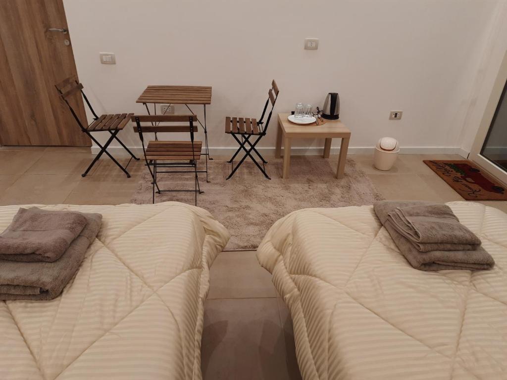 a bedroom with two beds and a table and chairs at Fantastic new rooms close to New Cairo Festival City and airport in Cairo