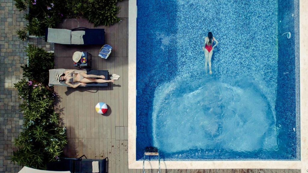 an overhead view of a woman swimming in a pool at Casa Collection in Tivat