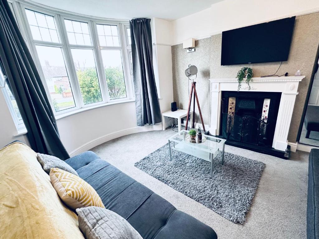 a living room with a blue couch and a fireplace at Impeccable 3-Bed House in Nottingham Central in Nottingham