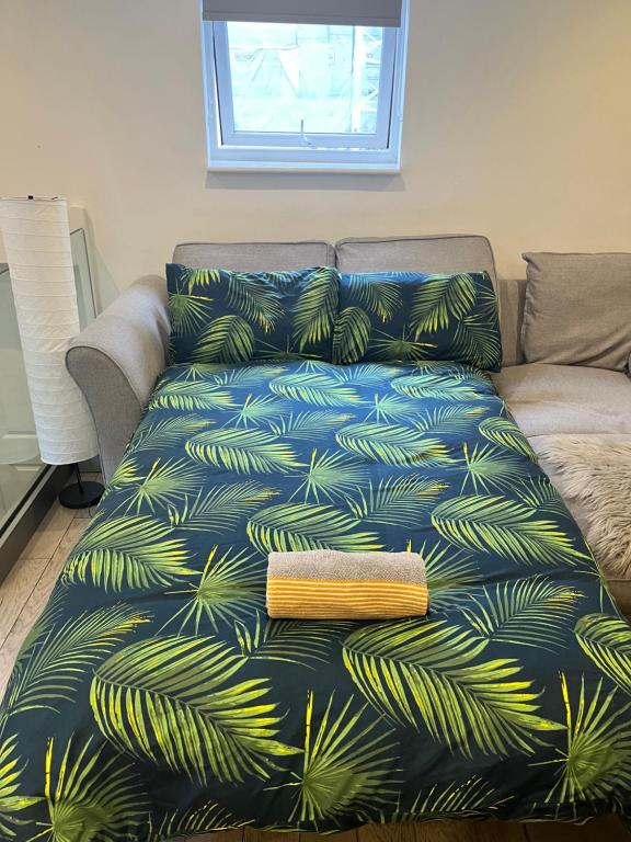 un sofá con una manta azul con hojas de palmera en Modern 1 Bedroom flat close to Vauxhall en Londres