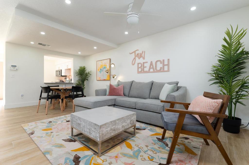 a living room with a couch and a table at Be A Nomad Lovely 2br 1blk from the Ocean in Jacksonville Beach