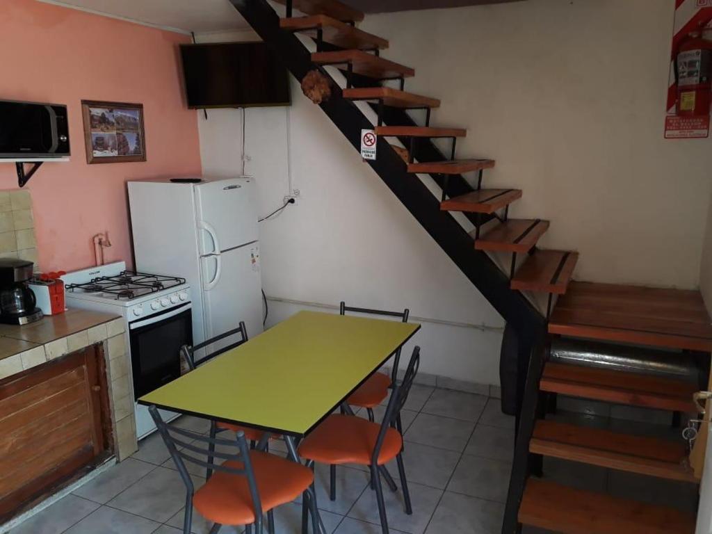 a kitchen with a table and a kitchen with a spiral staircase at Departamentos Lina in El Bolsón