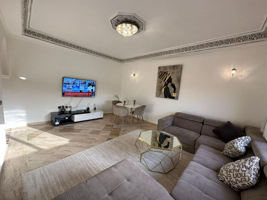 un soggiorno con divano e tavolo di Luxury, Cosy Apartement (Wifi, Balcony, Parking) a Marrakech