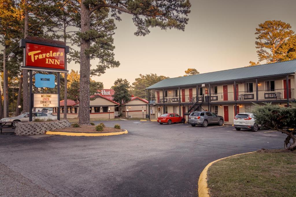 une auberge d'hôtel avec des voitures garées dans un parking dans l'établissement Traveler's Inn, à Eureka Springs