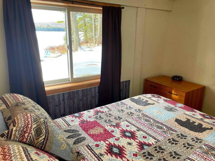 - une chambre avec une couette sur un lit et une fenêtre dans l'établissement Sandy Hollow Vacation Home, à White