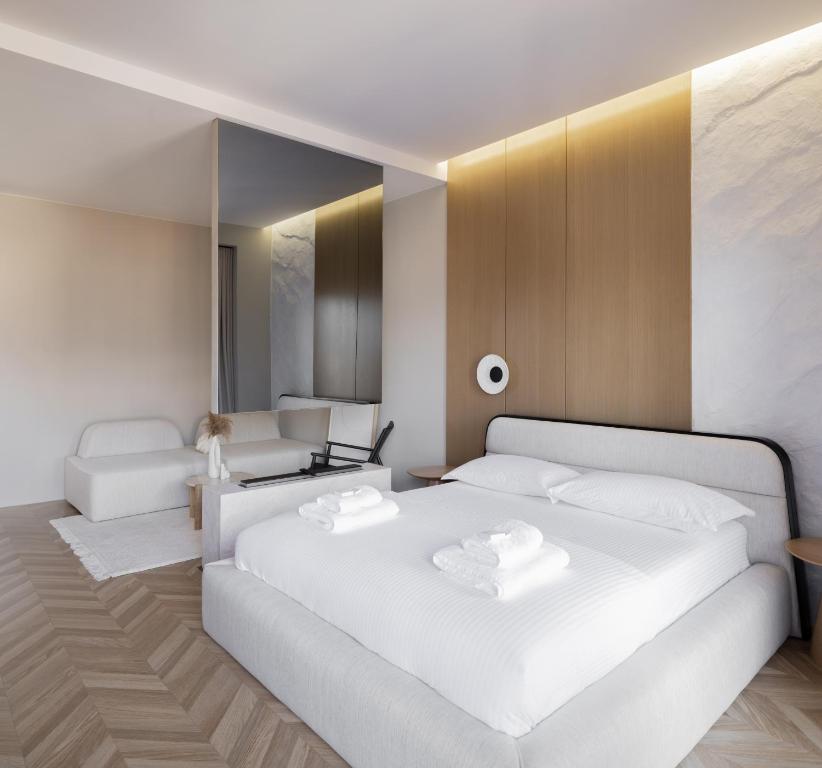 a bedroom with a large white bed and a desk at Square INN Garden Aparthotel in Tirana