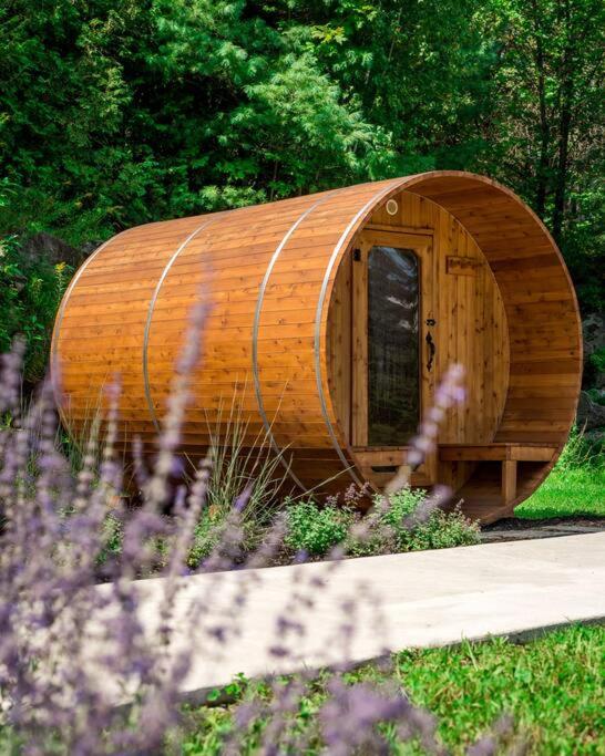 un edificio circular de madera con una puerta en un jardín en Suite 109 - Destination Mont-Orford, en Magog-Orford