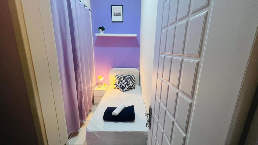 a small room with a white door and a bed at Peaceful Partition Room Near Mall of the Emirates in Dubai