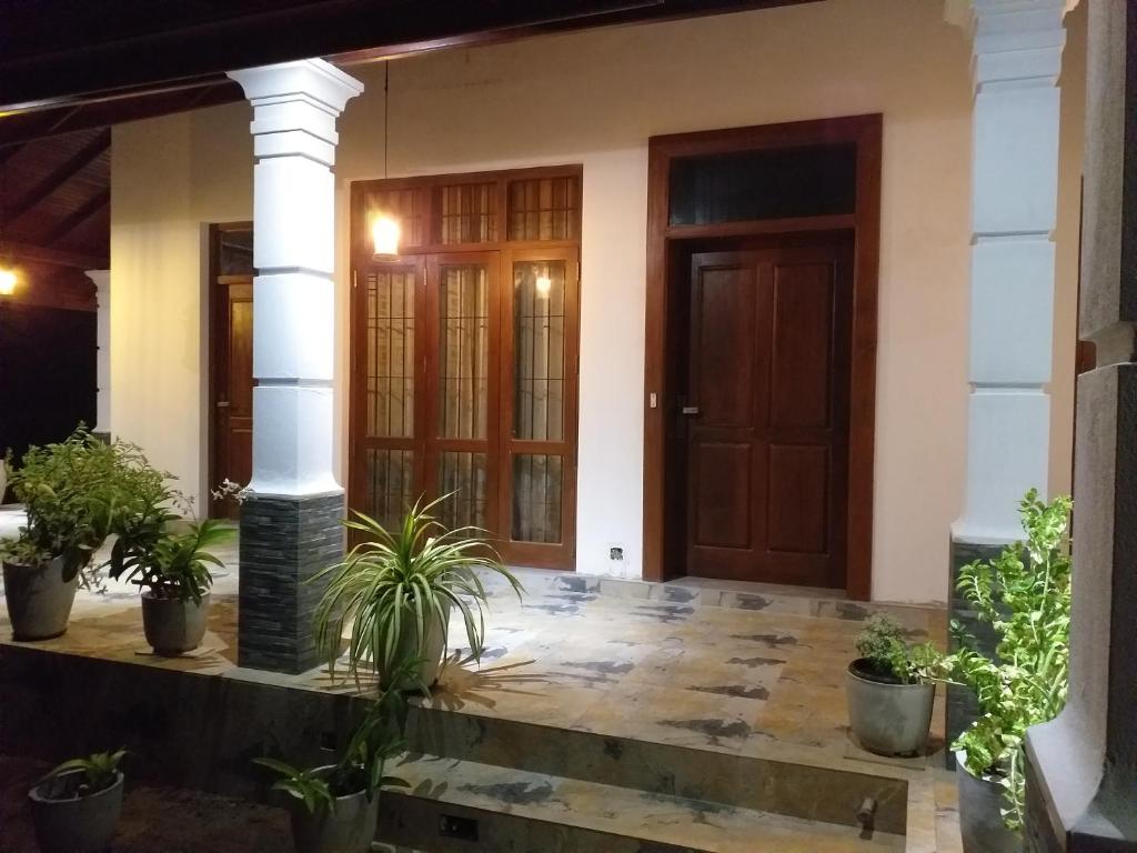 a front door of a house with potted plants at Bel vedere in Minuwangoda