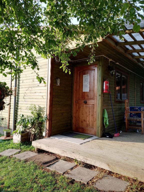 ein Haus mit einer Holztür und einer Veranda in der Unterkunft Cabaña Don Tito en Buchupureo in Cobquecura