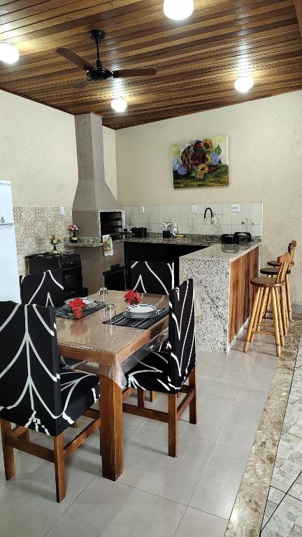 una cucina con tavolo e sedie in legno in una stanza di Cantinho da paz a Caraguatatuba