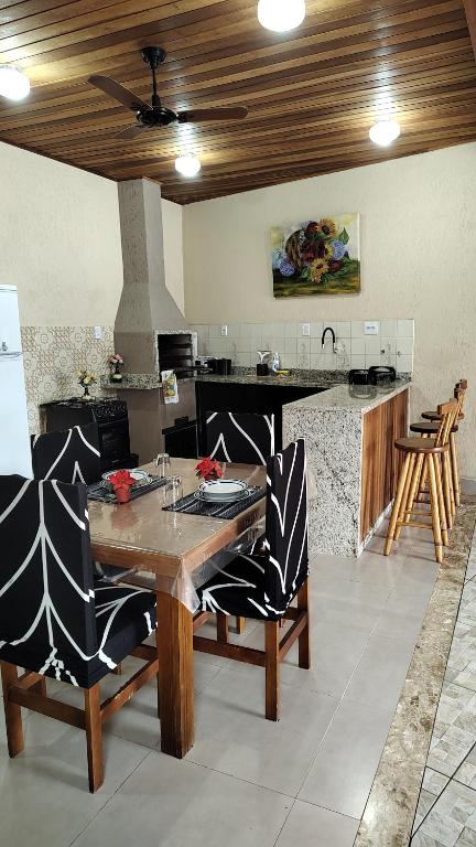 a kitchen with a wooden table and chairs in a room at Cantinho da paz in Caraguatatuba