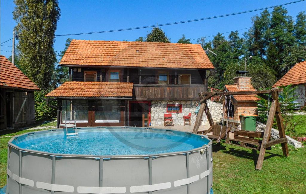 a house with a pool in front of a house at Stunning Home In Netretic With Wi-fi in Netretić