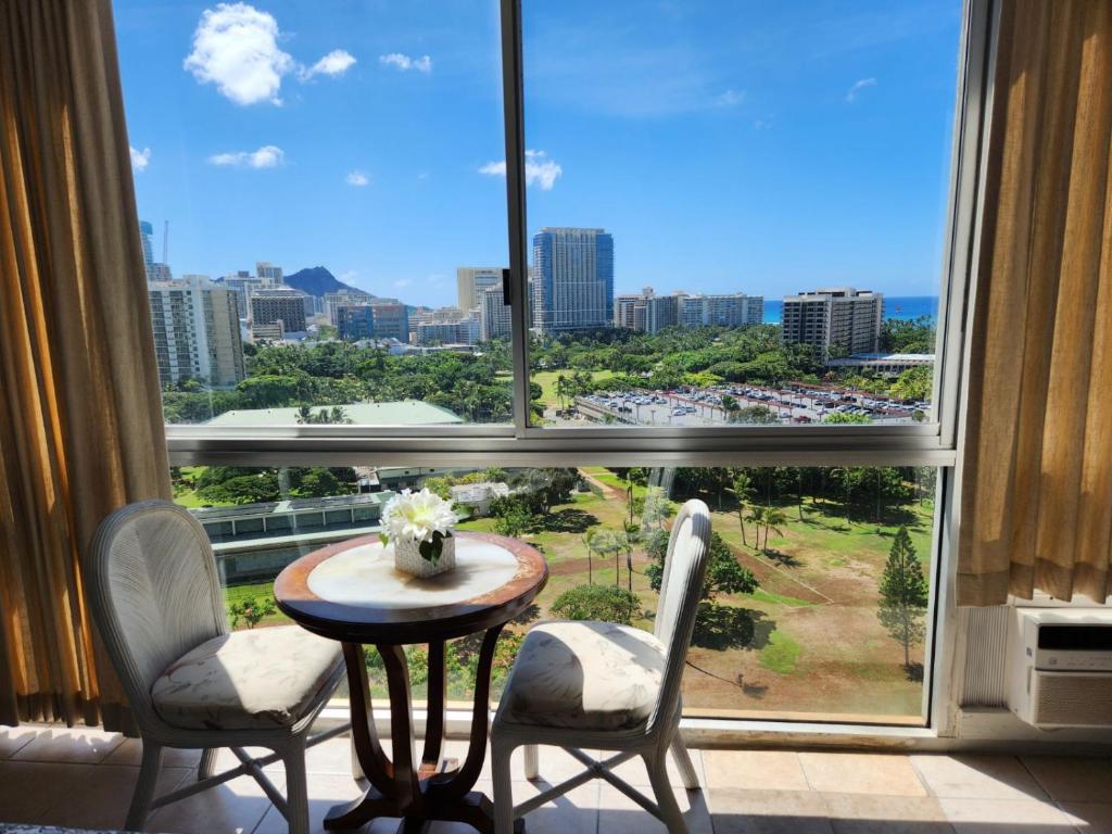 a room with a table and two chairs and a large window at Little Paradise in Waikiki with Lovely Ocean -15F in Honolulu