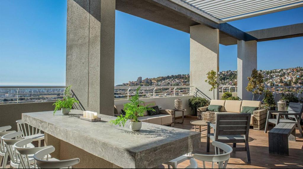 eine Terrasse mit einem Tisch und Stühlen auf dem Balkon in der Unterkunft Departamento Viña del Mar in Viña del Mar