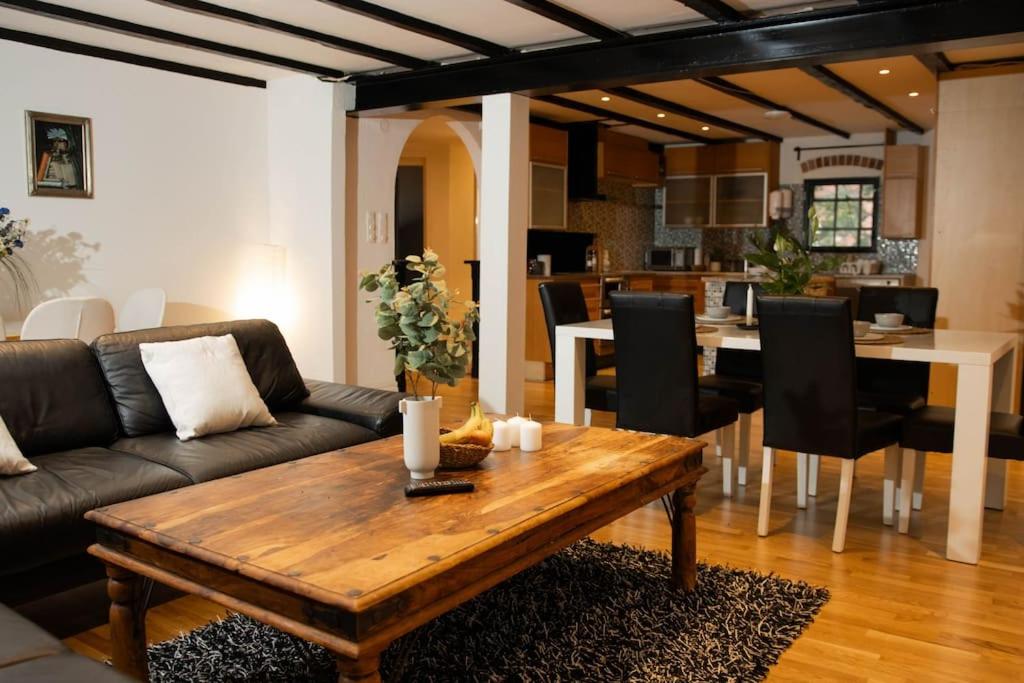 a living room with a couch and a table at Historical Malt Factory Apartment, 6 Bedrooms, sleeps 12 , Hot Tub in Helsingborg