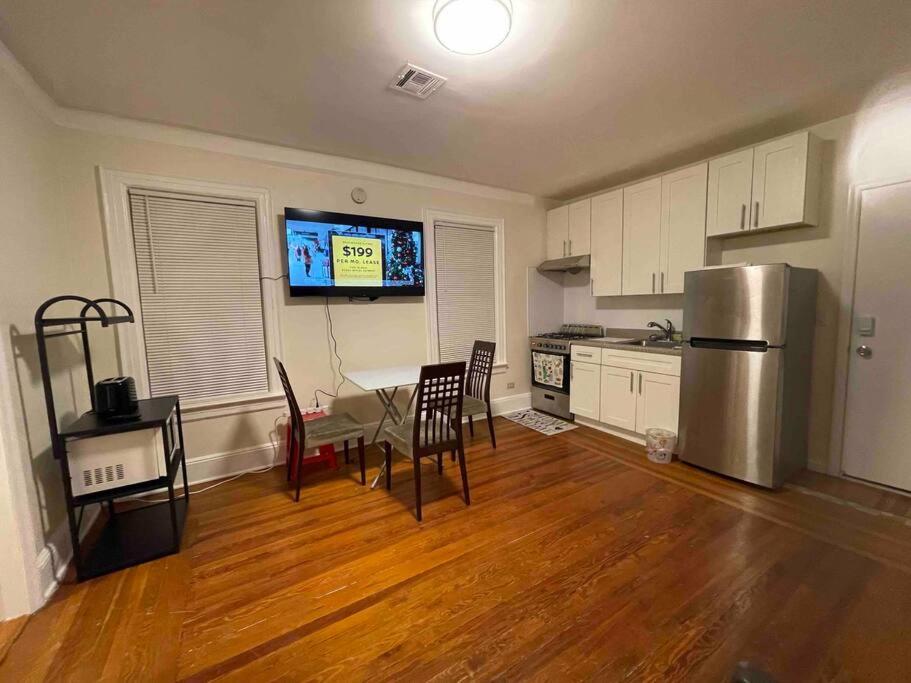 cocina con nevera, mesa y sillas en Entire Cozy 1BR Apartment in heart of Queens L en Whitestone