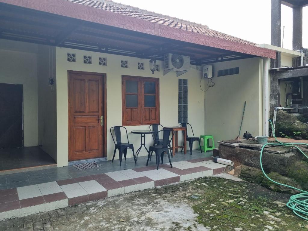 une terrasse avec des chaises et une table en face d'une maison dans l'établissement Diyan Padhang Homestay Kamar5, à Jetis