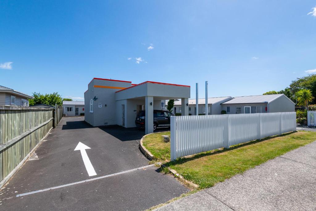 a parking lot in front of a building with a fence at Aurora City Suites Motel in Rotorua