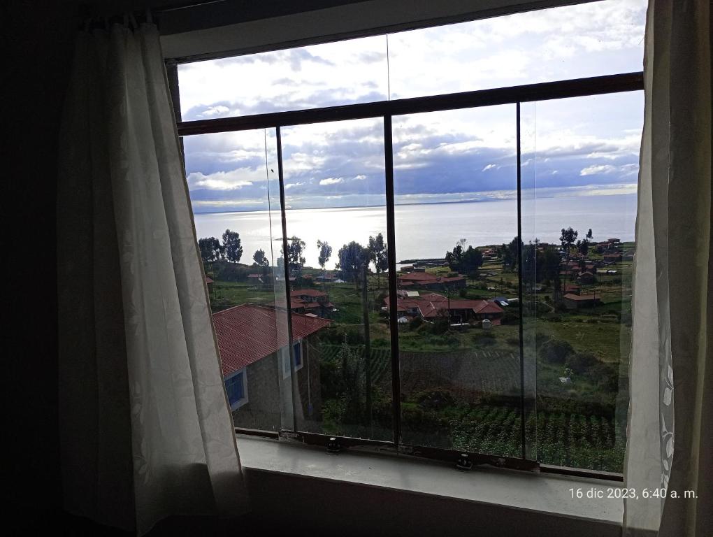 a window with a view of the ocean at Tukuypaj Amantani in Amantani