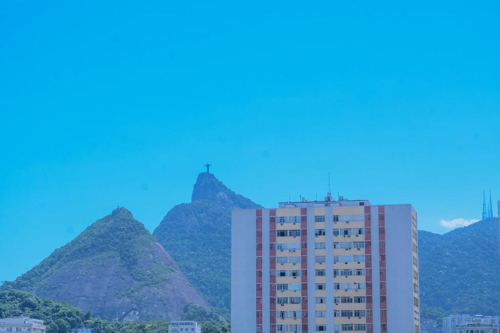 a tall building with mountains in the background at Flamengo Home in Rio de Janeiro