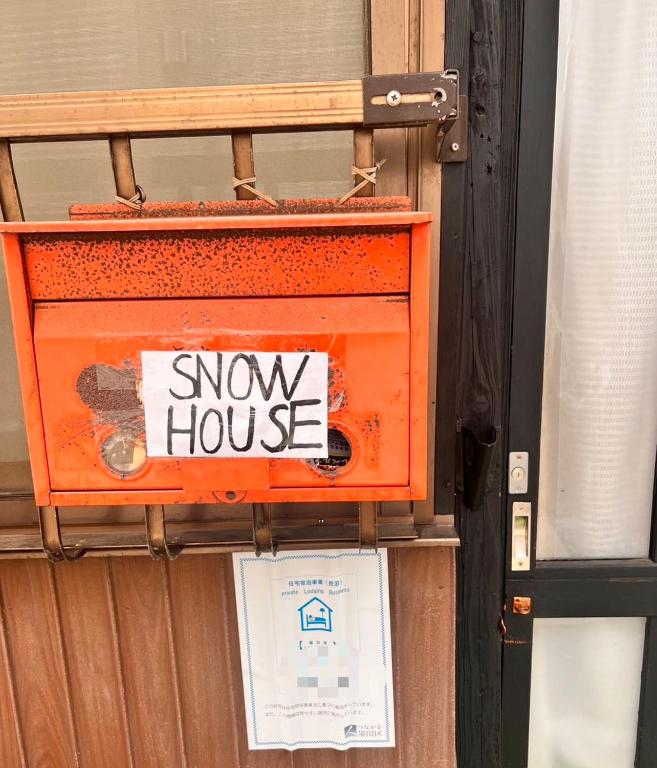 une boîte orange avec un panneau indiquant un déménagement dans l'établissement SnowHouse, à Tokyo