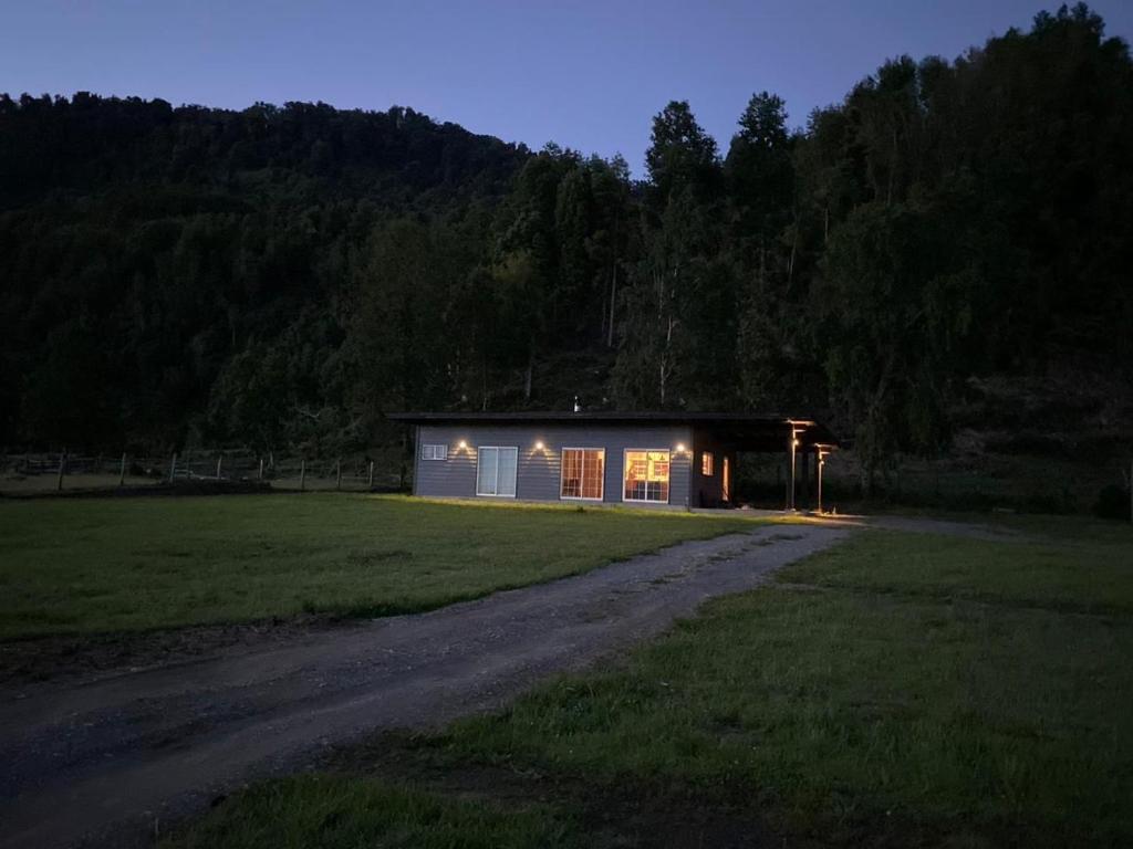 a small house with lights in a field at night at Cabaña Azul in Riñinahue