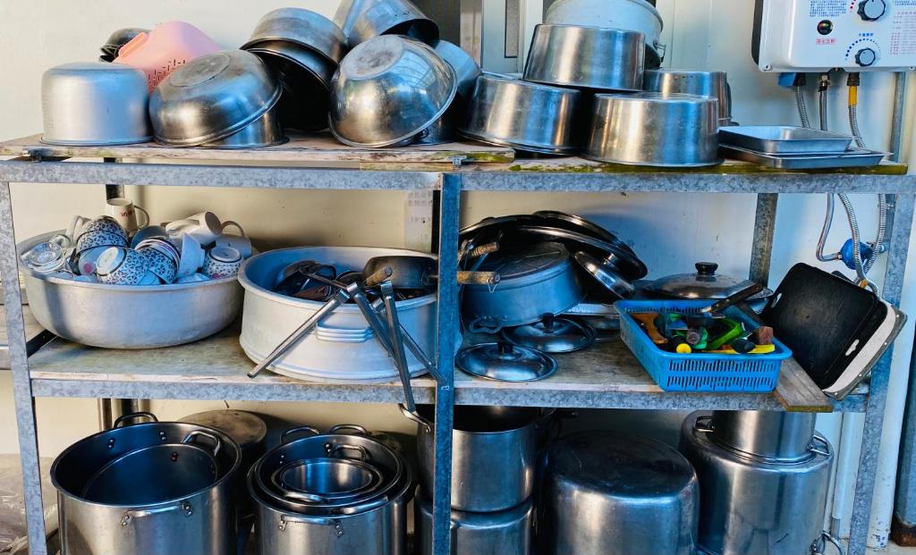 une étagère remplie de casseroles, de poêles et d'autres articles dans l'établissement Alishan Mao Hsin, à Fenchihu