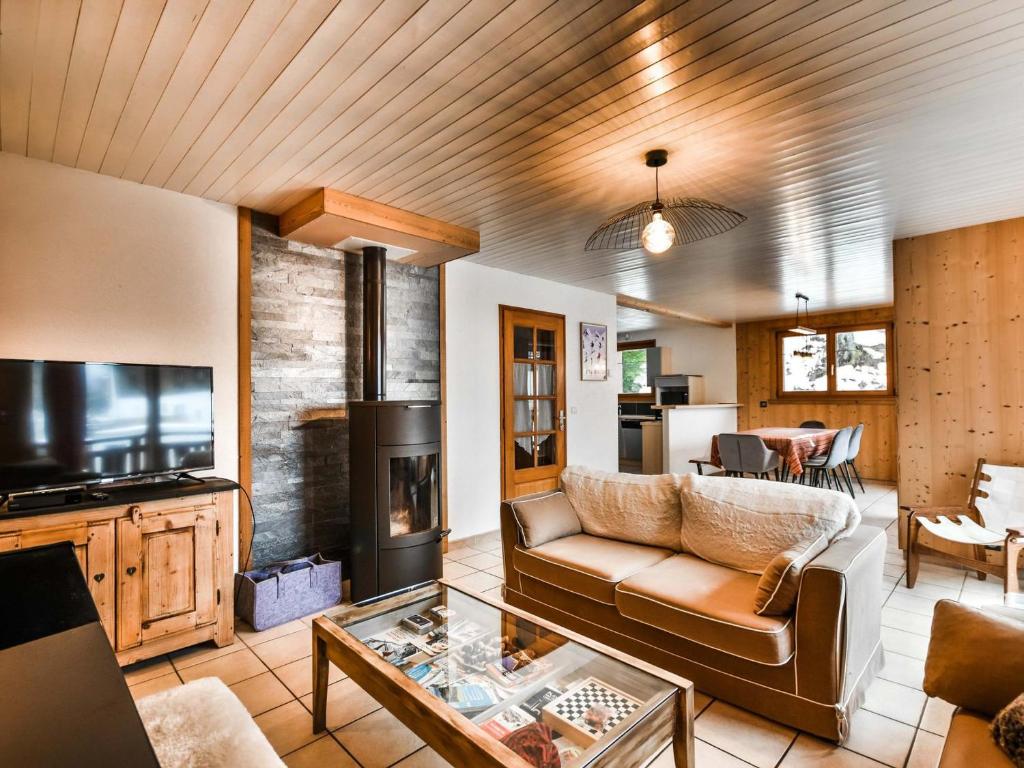 un salon avec un canapé et une télévision dans l'établissement Chalet familial confortable 7 pers, 800m des pistes, terrasse, parking, WiFi, équipements modernes - FR-1-685-77, aux Gets