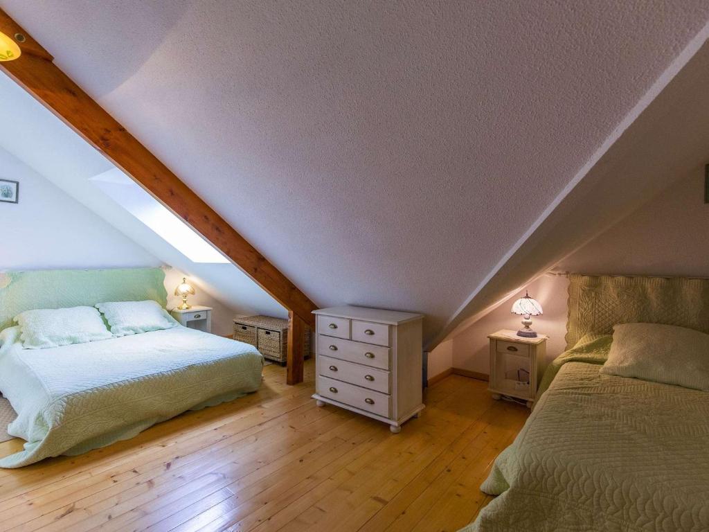 a attic bedroom with two beds and two night stands at Appartement Cauterets, 4 pièces, 7 personnes - FR-1-401-276 in Cauterets