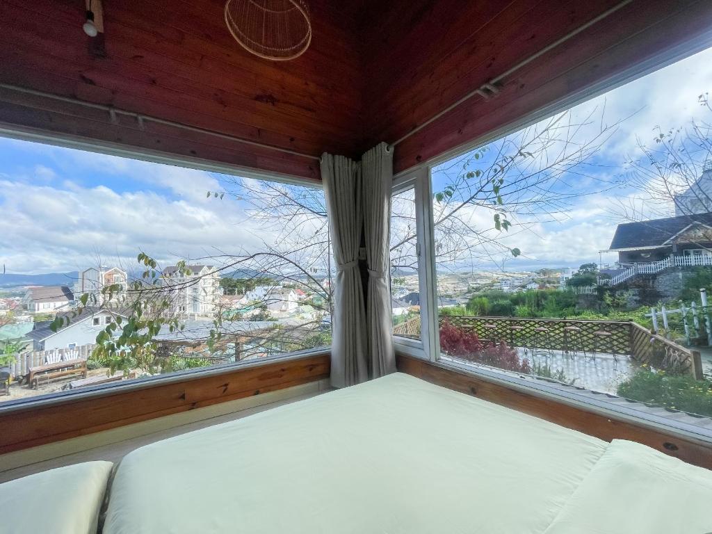 Ce lit se trouve dans un dortoir doté d'une grande fenêtre. dans l'établissement Đom Đóm House Đà Lạt, à Đà Lạt
