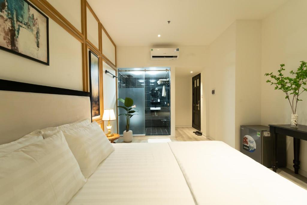 a bedroom with a large white bed and a shower at Khách sạn Gấu Hotel in Hanoi