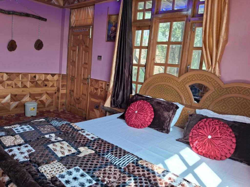 um quarto com uma cama com almofadas vermelhas e pretas em Cozee Mozee Family Homestay em Kufri