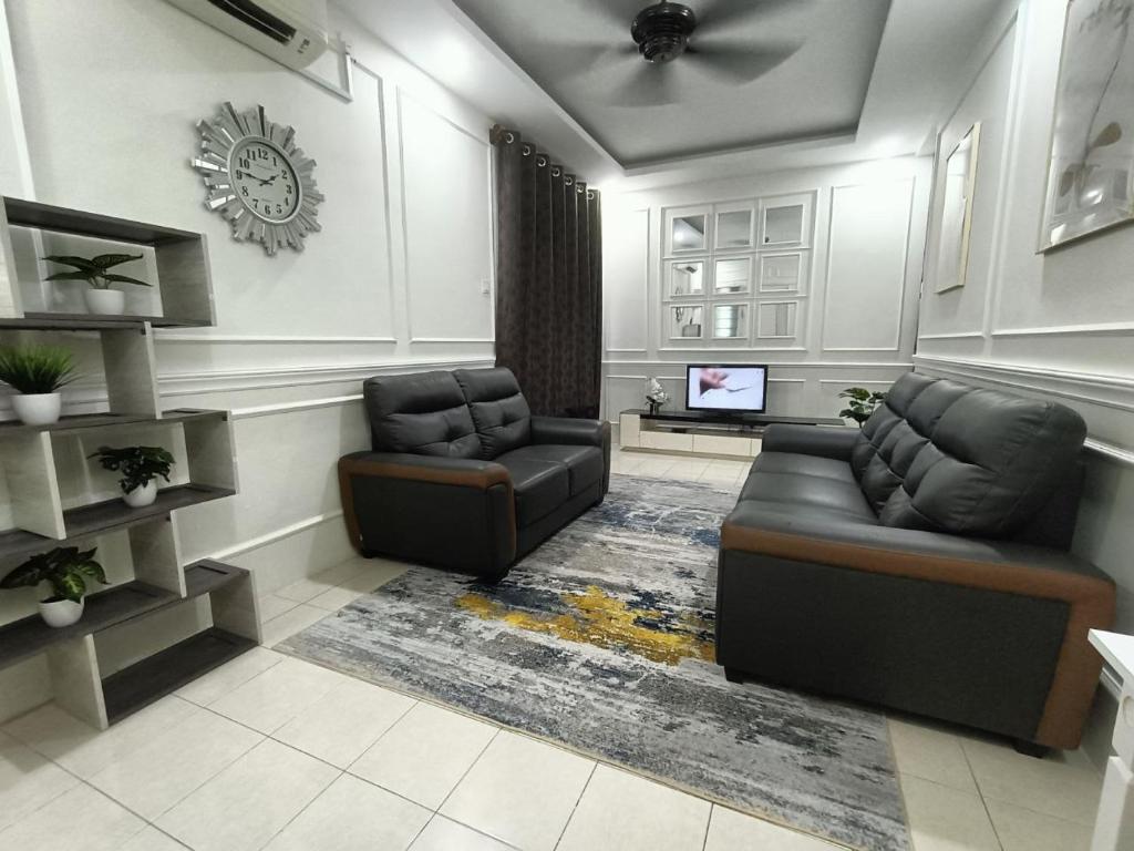 uma sala de estar com um sofá e uma cadeira em Ceri Kluang Homestay (Corner Lot) em Keluang