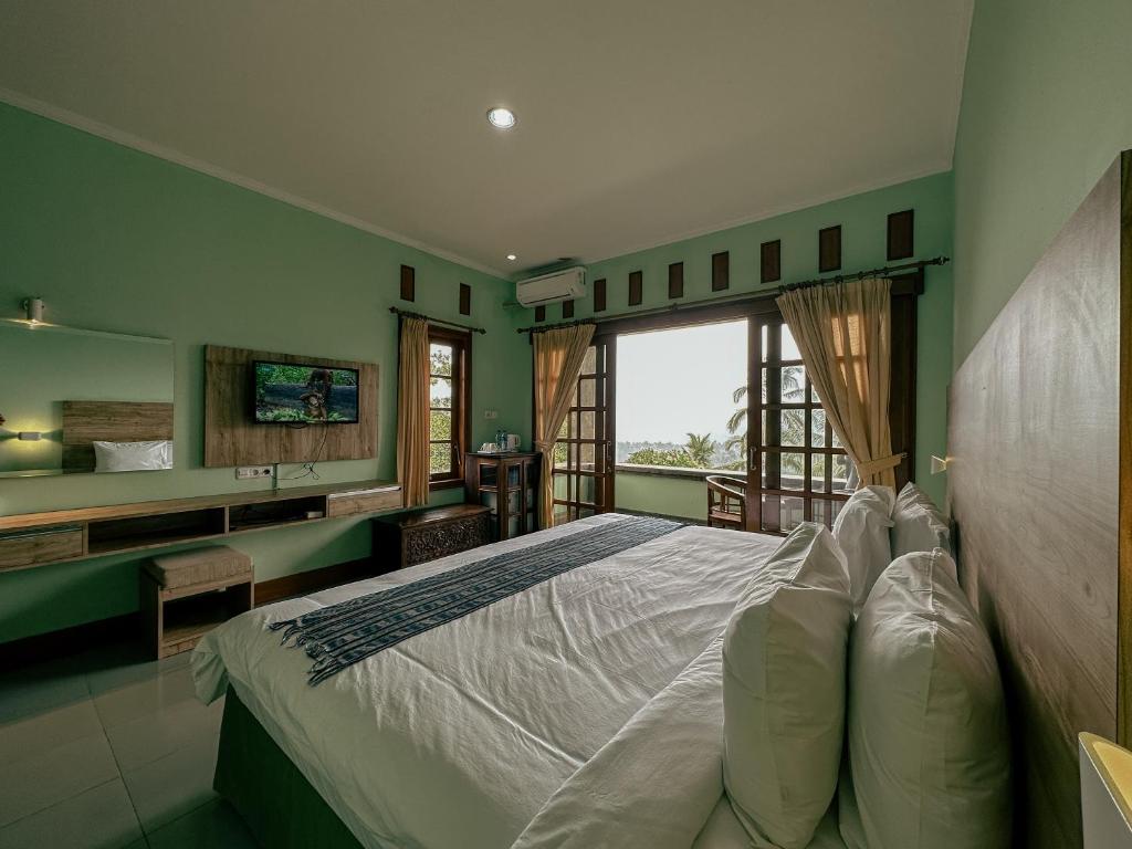 um quarto com uma cama grande e uma janela grande em VILLA IPSA em Munduk
