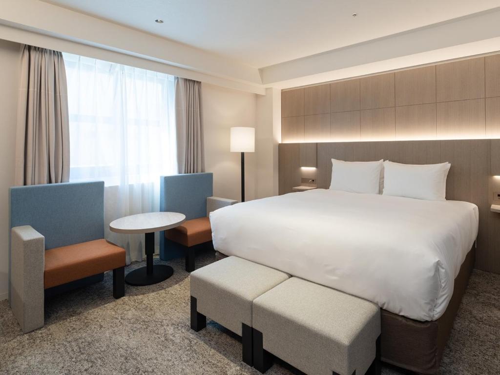 福岡市にあるHOTEL IL PALAZZO - Vacation STAY 68248vのベッド、テーブル、椅子が備わるホテルルームです。