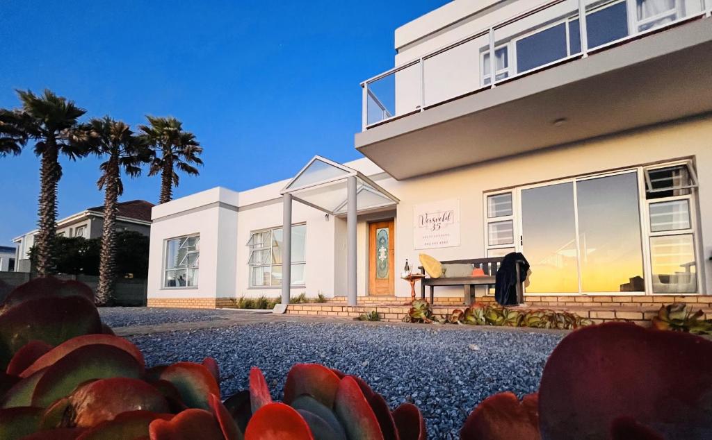 a house with palm trees in front of it at LazyYzer in Yzerfontein