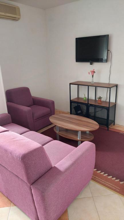 - un salon avec un canapé violet et une table dans l'établissement Apartment Matilda, à Split