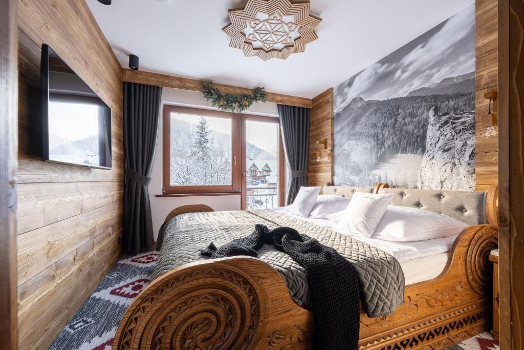 a bedroom with a bed and a wall with a painting at Willa Polana pod Nosalem in Zakopane